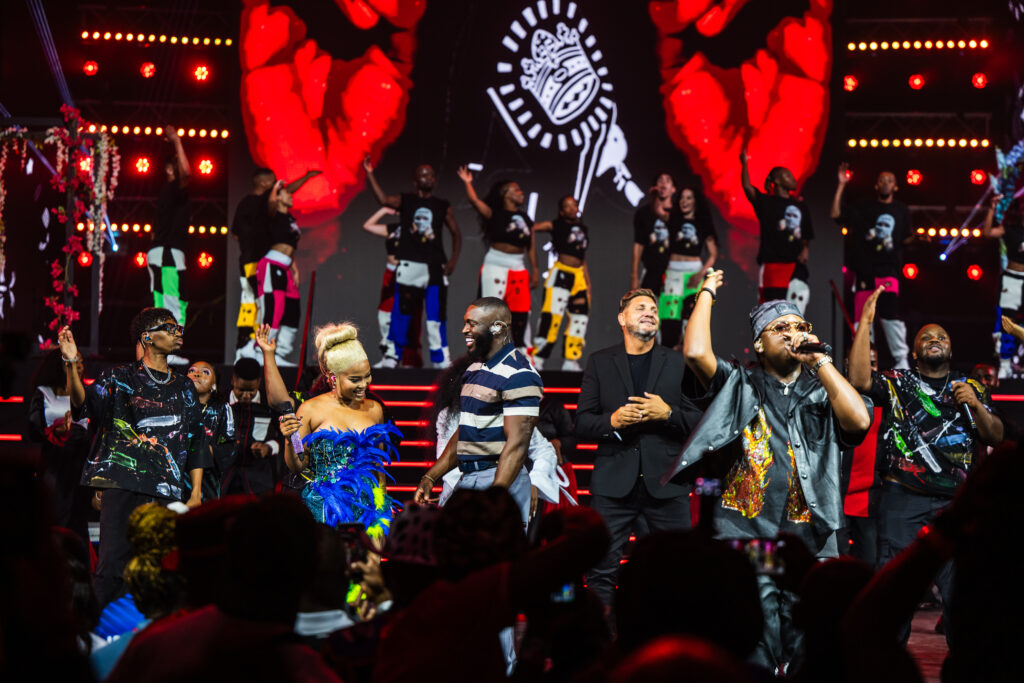 Mahindra Fusion Fest All About Now amapiano performance featuring Zee Nxumalo, Focalistic and Daliwonga on stage, with fashion by Munkus and street art by Bushy Wopp, energising the crowd with vibrant music and visuals.