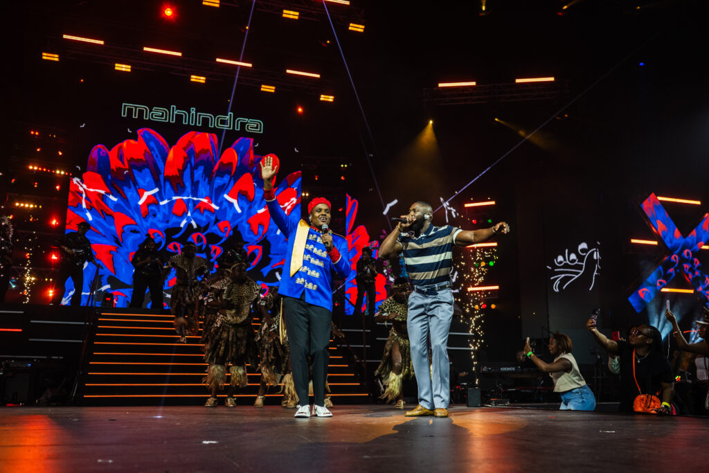 Mahindra Fusion Fest All About Now amapiano performance featuring Zee Nxumalo, Focalistic and Daliwonga on stage, with fashion by Munkus and street art by Bushy Wopp, energising the crowd with vibrant music and visuals.