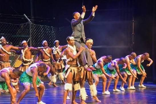 Sarafina cast performing a high-energy dance sequence on stage at Soweto Theatre, dressed in school uniforms, capturing a powerful moment of movement, rhythm and protest theatre commemorating 50 years since the Soweto Uprising in South African history.